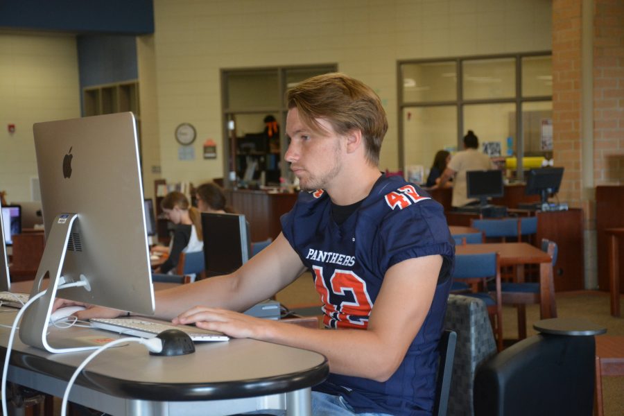 Senior Bryce Painter works on college applications in the library. 