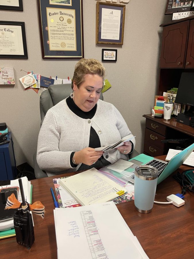 Assistant Principal Amy Driggers looks through photos of previous students. Driggers has developed close relationships with many students over her career. 