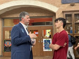 Principal Andrew McMillan talks to senior Dylan Lunsford in the hallway. McMillan will leave Chapman at the end of the school year.